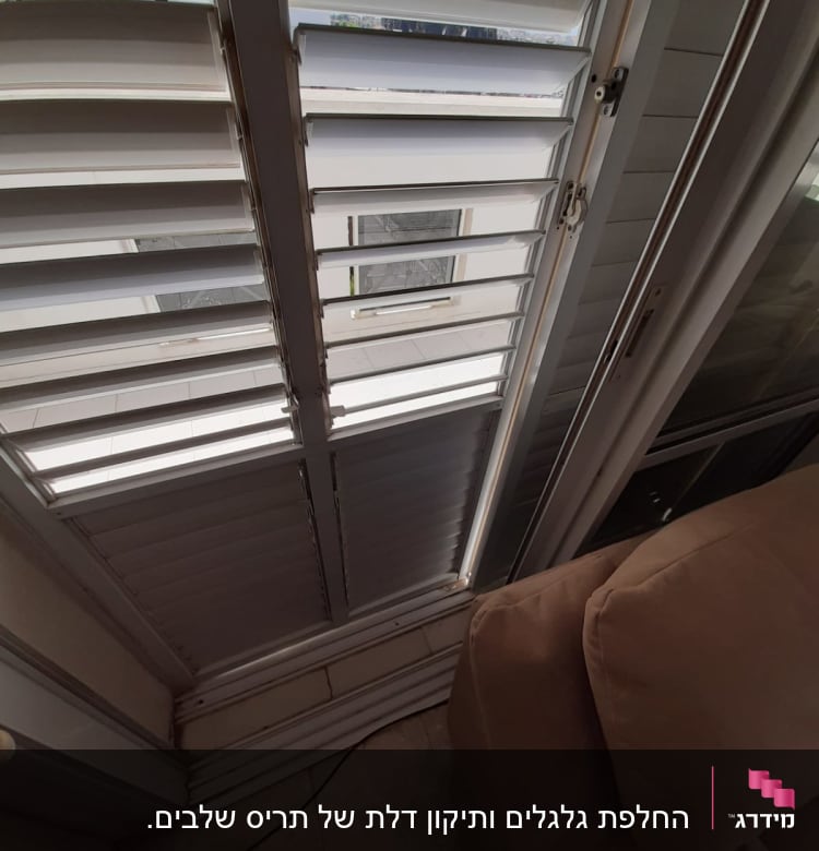 תריסים לבנים פתוחים למחצה עם מנגנון סגירה